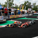 Three remote control Formula 1 cars racing on a track with spectators watching